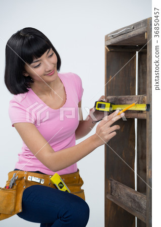 Woman measuring furniture with tape measure 36850457