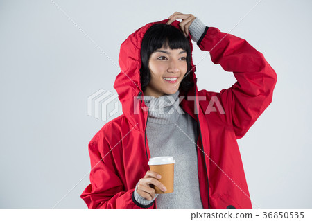 Woman in red jacket having coffee against white background Woman in red jacket having coffee against white background 36850535