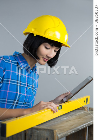 Female architect measuring plywood with engineer scale Female architect measuring plywood with engineer scale 36850537
