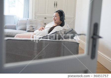 Pregnant woman listening music on headphones 36851757