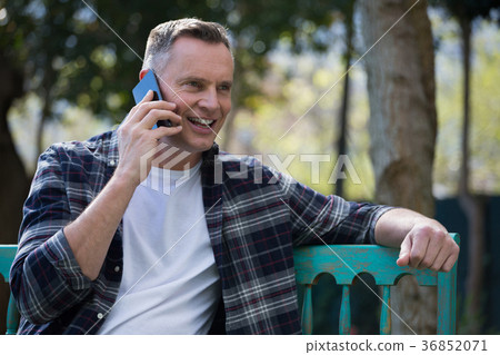 Man talking on mobile phone in garden 36852071