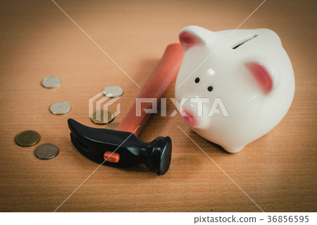 Little boy breaking a piggy bank 36856595