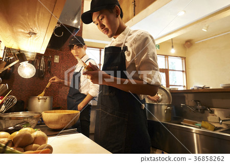 Staff cooking in a cafe kitchen Staff cooking in a cafe kitchen 36858262