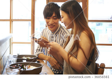 Couple taking food with smartphone 36858381