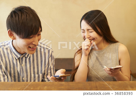 Couple taking food with smartphone Couple taking food with smartphone 36858393