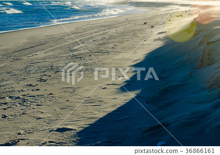 View of a sunset on a white sand beach View of a sunset on a white sand beach 36866161