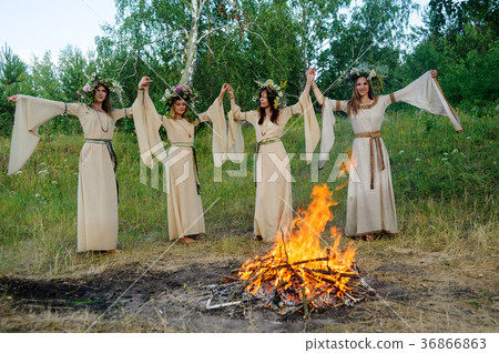 Beautiful women with flower wreath near bonfire 36866863