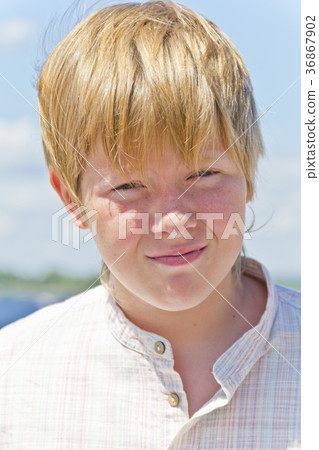 Portrait of serious boy on blue sky Portrait of serious boy on blue sky 36867902