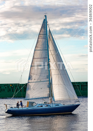 Blue sailboat against cargo ship 36869002