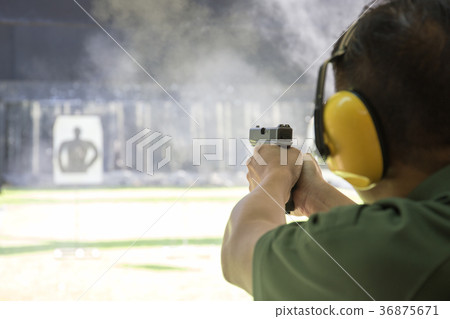 man firing automatic pistol  in shooting range 36875671