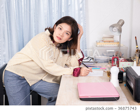 Asian creative woman sitting on her desk Asian creative woman sitting on her desk 36875743