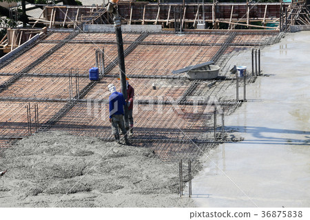 two labor work pouring liquid from cement mixer 36875838