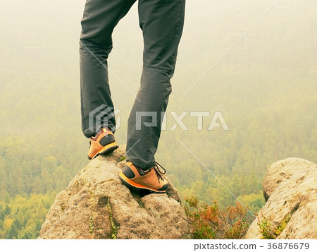 legs in orange hiking boots on mountain summit. 36876679