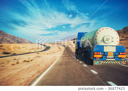 White tanker and trucks driving along picturesque 36877425