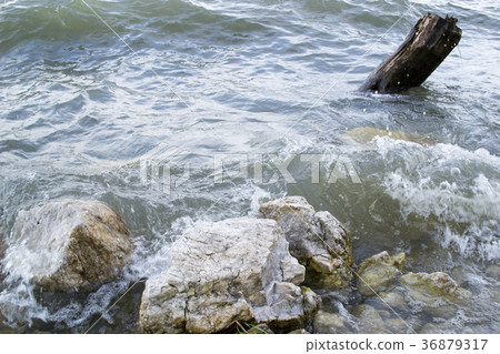 Waves breaking rocks on the shore of the lake Waves breaking rocks on the shore of the lake 36879317
