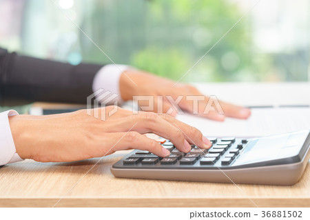 Hands of businessman pushing calculator Hands of businessman pushing calculator 36881502