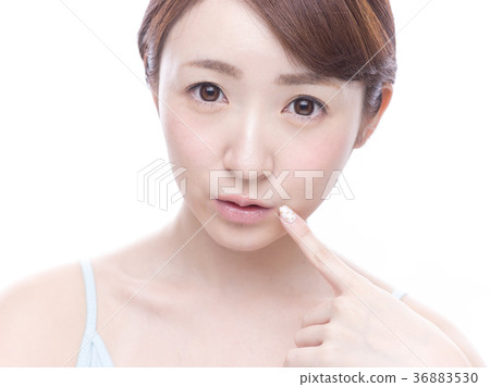 Young woman pointing at mouth Young woman pointing at mouth 36883530