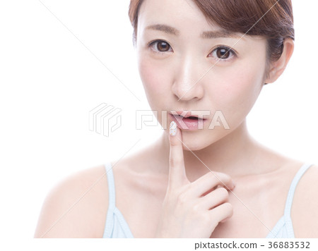Young woman pointing at mouth Young woman pointing at mouth 36883532