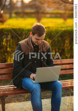 The young manager working on a laptop in the park The young manager working on a laptop in the park 36883981