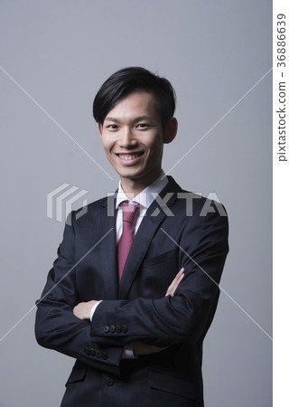 一套衣服的年輕人與被交叉的雙臂,微笑 一套衣服的年輕人與被交叉的雙臂,微笑 36886639