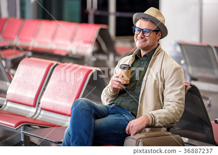 Optimistic man in glasses is enjoying fresh coffee 36887237