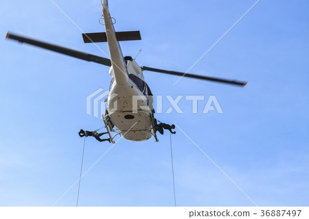 Soldier rappelling from helicopter in blue sky 36887497