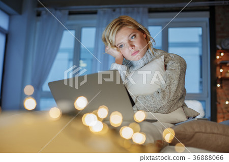 Sad girl relaxing at house with laptop Sad girl relaxing at house with laptop 36888066