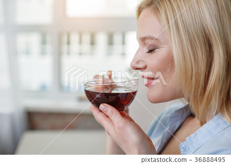 Dreamful female sniffing hot drink 36888495