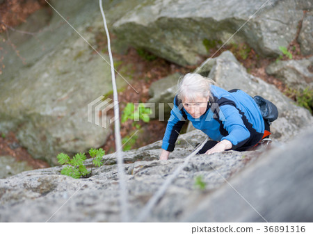 Woman practices in climbing at the rock in the mountains Woman practices in climbing at the rock in the mountains 36891316