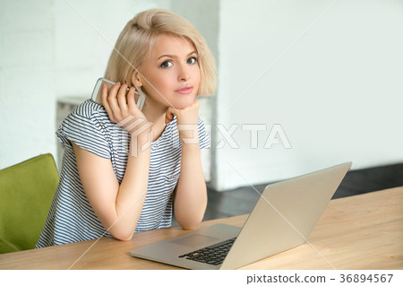 Girl working on computer and holding phone Girl working on computer and holding phone 36894567