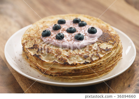 blini or crepes with yogurt and blueberries 36894660