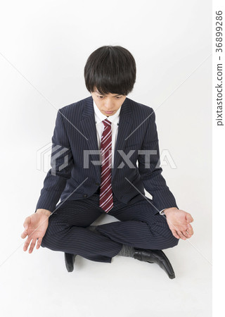 Young businessman meditating 36899286