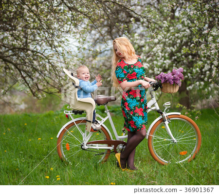 Blonde female with city bicycle with baby in bicycle chair Blonde female with city bicycle with baby in bicycle chair 36901367