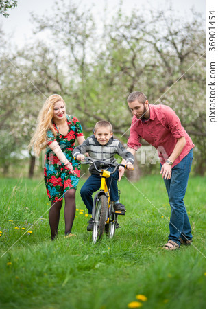 Young parents teaching his son to ride a bike 36901454