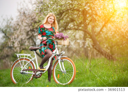 Female cyclist with vintage white bicycle in spring garden Female cyclist with vintage white bicycle in spring garden 36901513