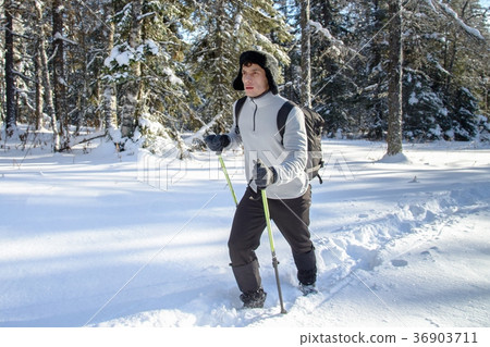 Young Man hiker with backpack trekking in winter Young Man hiker with backpack trekking in winter 36903711
