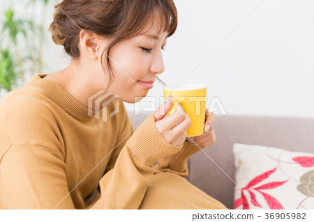 一個女人在一個房間裡喝一杯 36905982