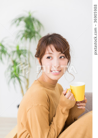 A woman drinking a drink in a room A woman drinking a drink in a room 36905988