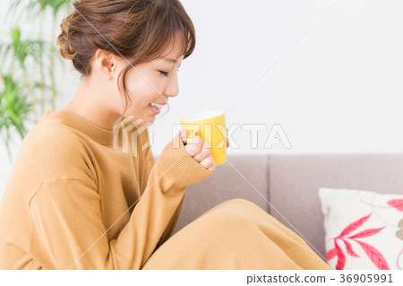 A woman drinking a drink in a room A woman drinking a drink in a room 36905991
