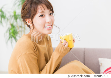 A woman drinking a drink in a room A woman drinking a drink in a room 36905992