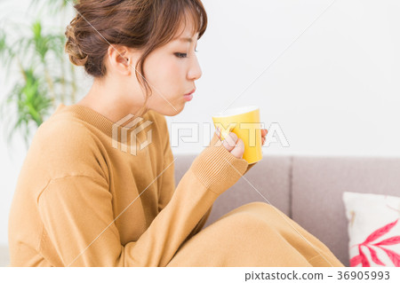 A woman drinking a drink in a room A woman drinking a drink in a room 36905993