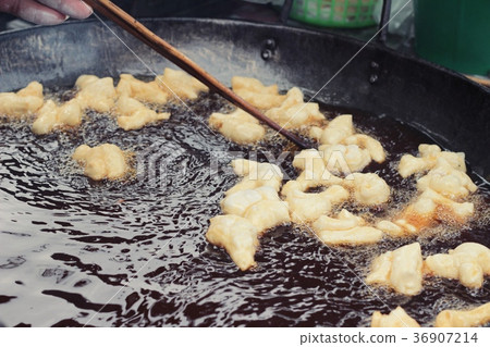 Making deep-fried dough stick in market. Making deep-fried dough stick in market. 36907214