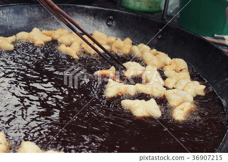 Making deep-fried dough stick in market. Making deep-fried dough stick in market. 36907215