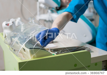 Close-up hand doctor takes a dental bur in dentist's office 36908747