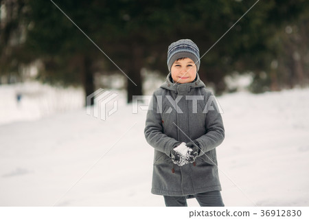 A little boy walks in the park in the winter 36912830