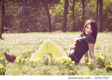 Beautiful young woman posing with yellow daffodils 36913367