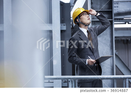 A businessman wearing a helmet 36914887