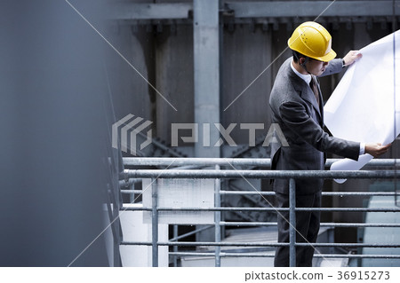 A businessman wearing a helmet 36915273