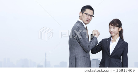 Businessman and businesswoman standing on the roof 36915409