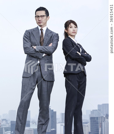 Businessman and businesswoman standing on the roof Businessman and businesswoman standing on the roof 36915431